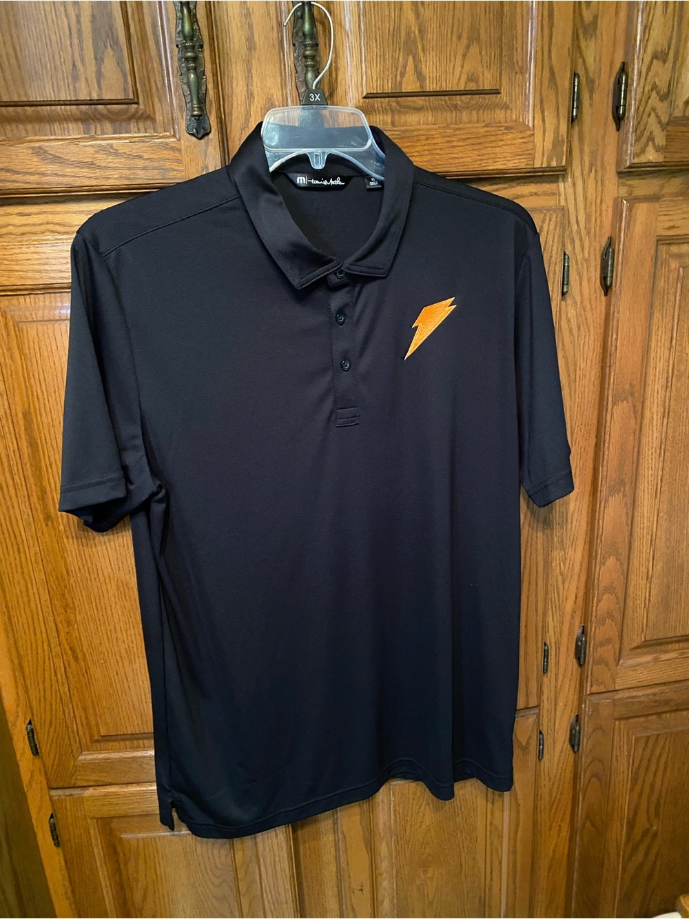Travis Mathew Black Polo with Orange Lightning Emblem